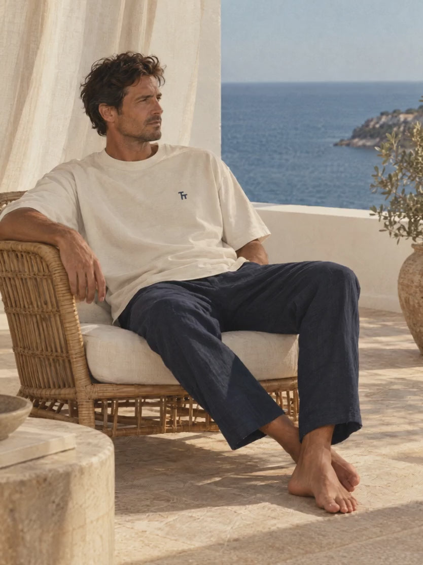 The Baseline Tee in ecru, worn with navy trousers